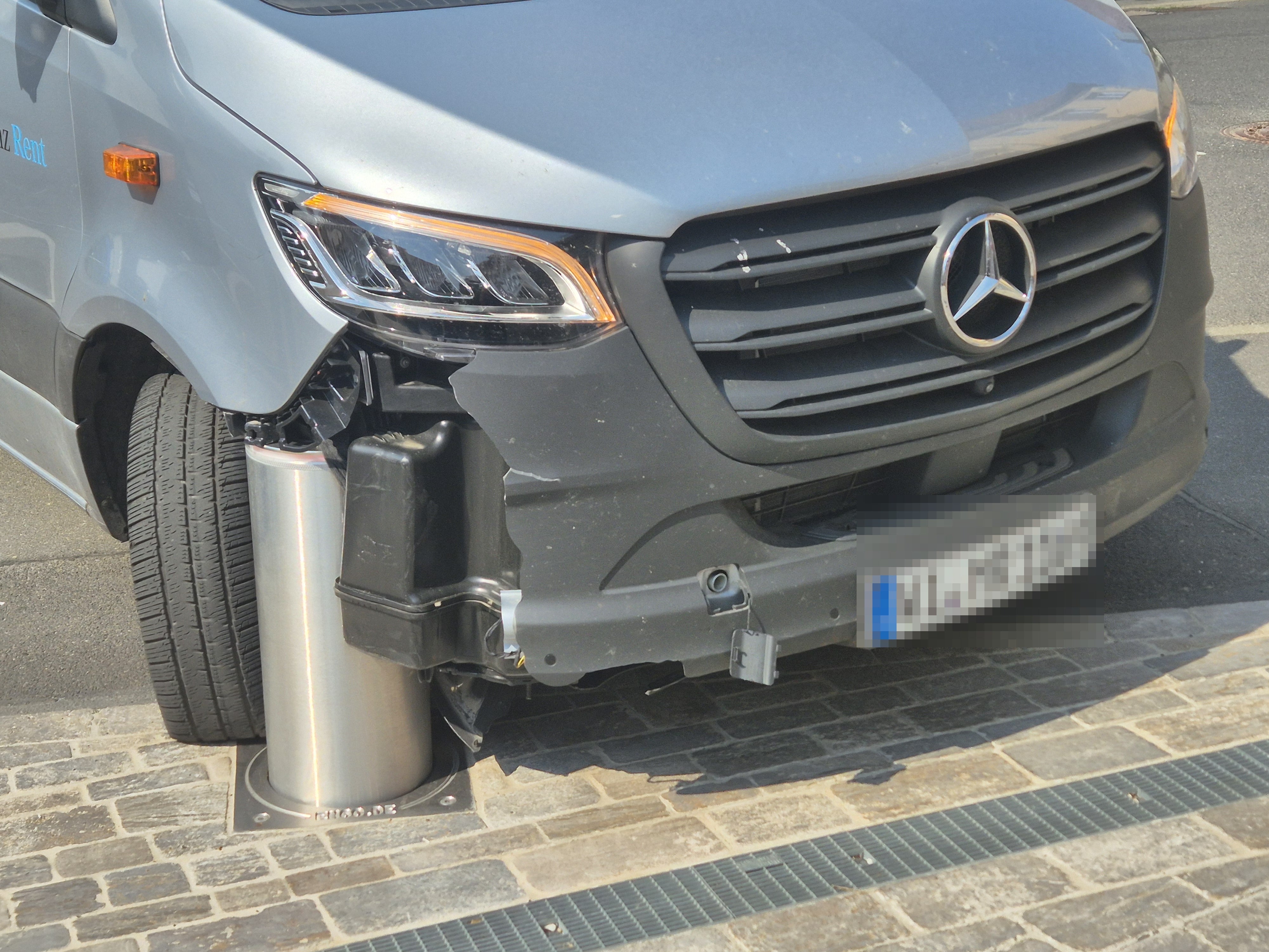 Lieferwagen mit Frontschaden am versenkbaren Poller in der Einfahrt