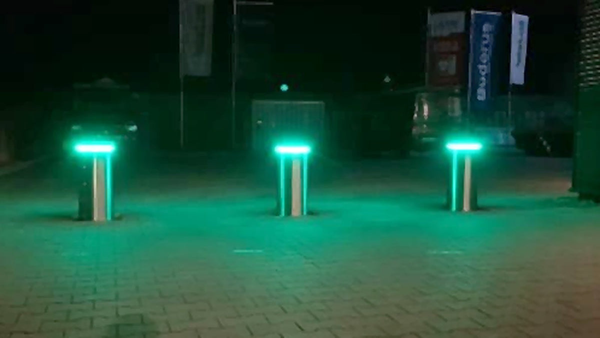Drei versenkbare Sicherheitspoller mit grüner LED-Beleuchtung sperren nachts die Zufahrt zu einem Gewerbegrundstück in Kassel