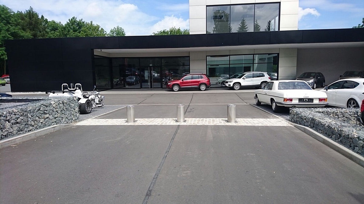 Drei versenkbare Edelstahl-Poller sperren die Zufahrt zum Ausstellungsplatz eines Autohauses, gesteuert über die SPS