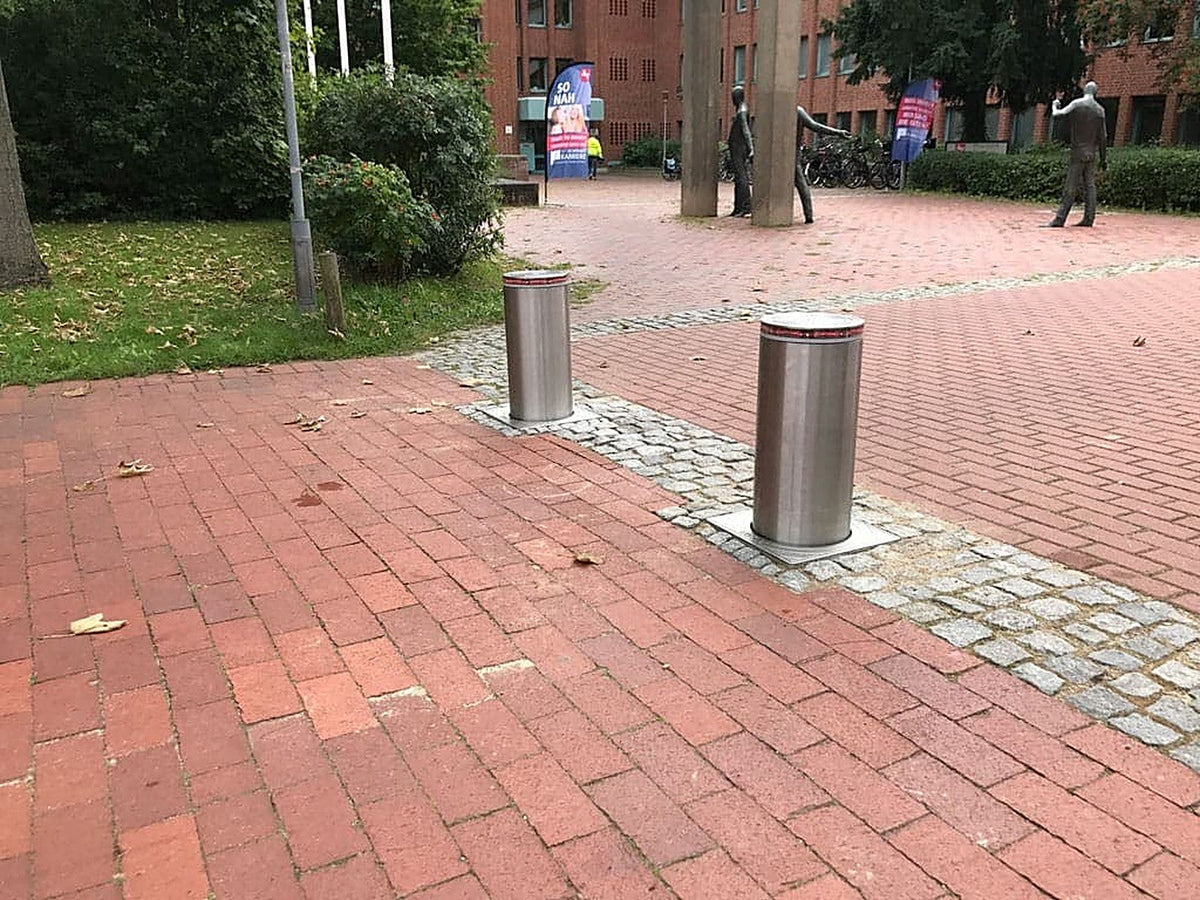 Zwei versenkbare Sicherheitspoller aus Edelstahl mit rotem Reflektorring sperren den Fußgängerbereich vor dem Finanzamt Lüneburg